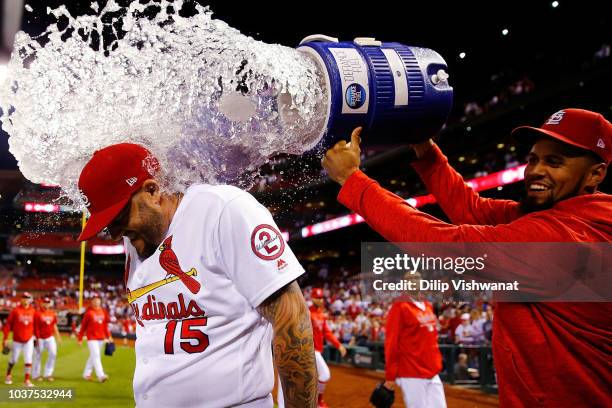 Francisco Pena of the St. Louis Cardinals douses Matt Adams of the St. Louis Cardinals after beating the San Francisco Giants at Busch Stadium on...