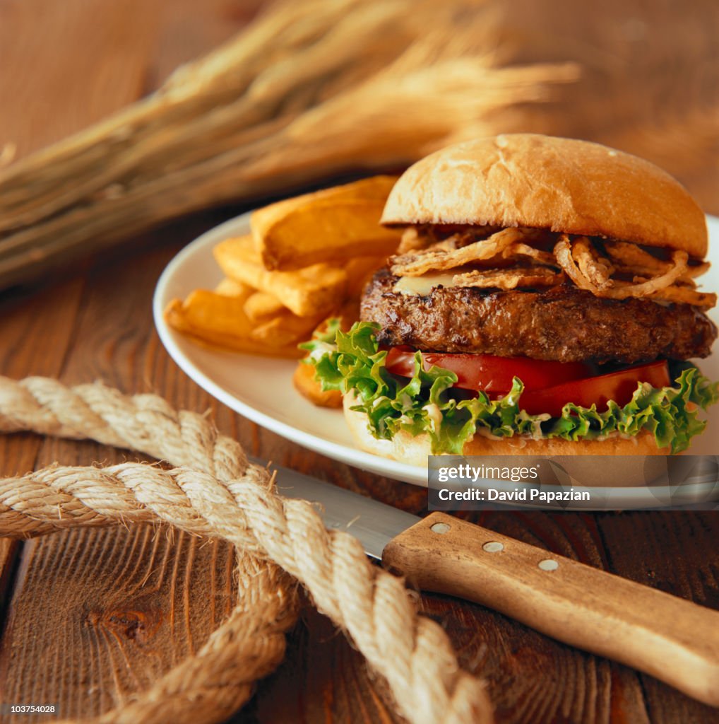 Hamburger and fries in a rustic table setting