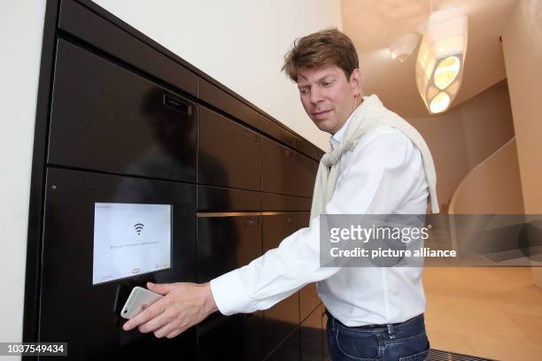 Founder of Xing and building owner of the 'Apartimentum', Lars Hinrichs, holds his smartphone against a networked mailbox system for identification...