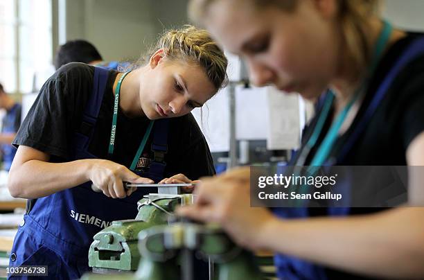 Female mechanical engineering trainees learn the basics of precision filing at the Siemens training center on September 1, 2010 in Berlin, Germany....