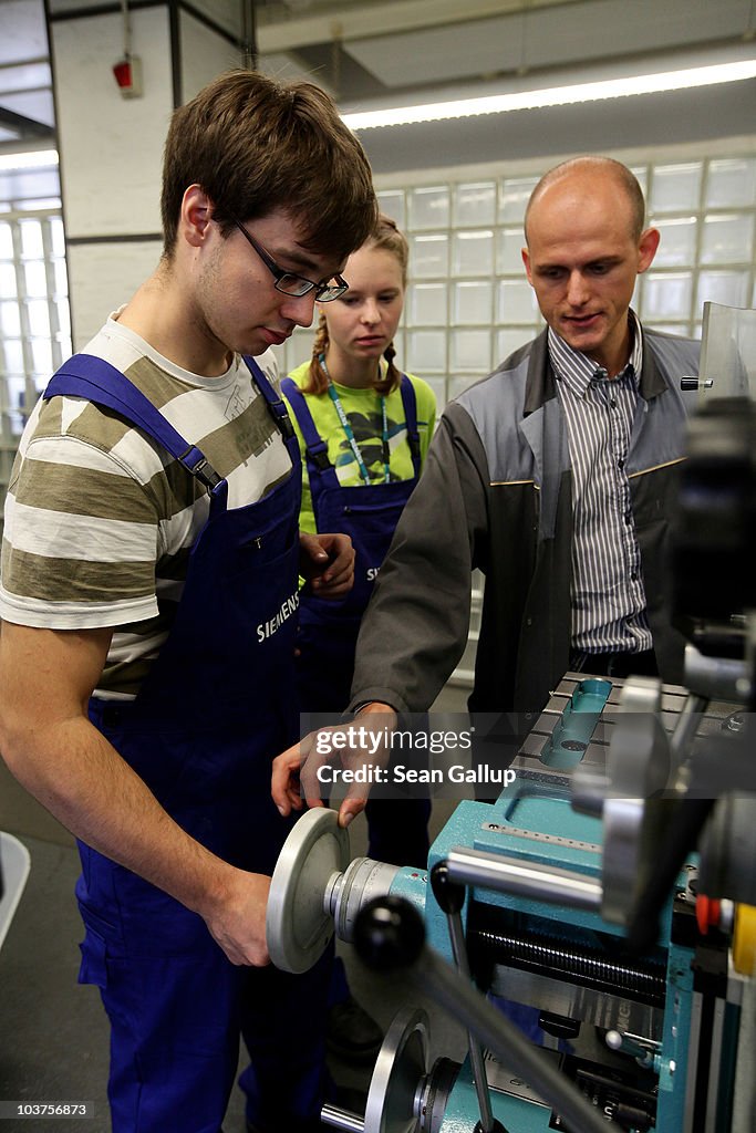An instructor teaches mechanical engineering trainees the operation ...