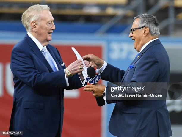 Retired Dodgers broadcaster Vin Scully, left, jokes with Dodgers Spanish language broadcaster Jaime Jarrin during a pregame ceremony inducting Jarrin...