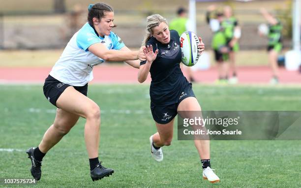 Kelly Rowe of University of Adelaide is tackled during the Aon Uni 7s match between University of Adelaide and University of Canberra on September...