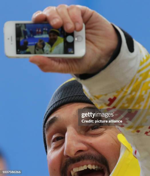 Georg Hackl, former luge champion of the German luge team, makes pictures after the Luge Doubles Run in Sliding Center Sanki at the Sochi 2014...