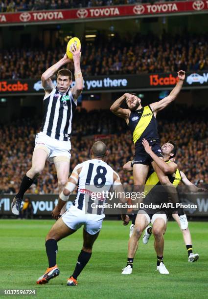 Mason Cox of the Magpies marks the ball against Shane Edwards and Alex Rance of the Tigers during the AFL Preliminary Final match between the...