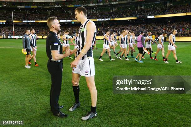 Magpies head coach Nathan Buckley speaks to Mason Cox of the Magpies before the national anthem during the AFL Preliminary Final match between the...