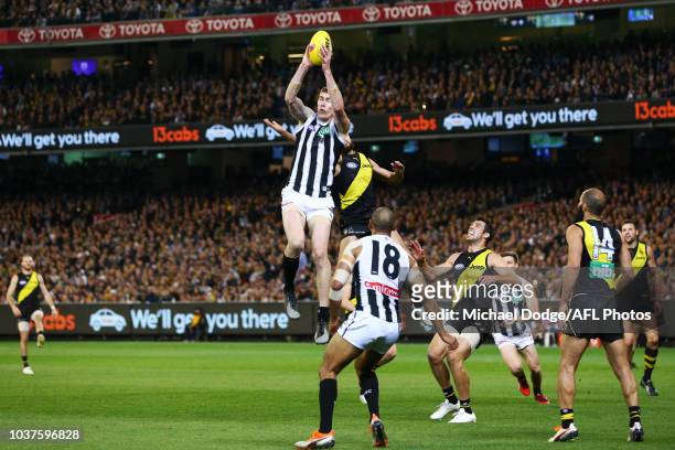Mason Cox of the Magpies marks the ball against Shane Edwards and Alex Rance of the Tigers during the AFL Preliminary Final match between the...