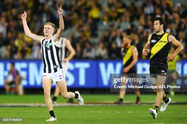 Jaidyn Stephenson of the Magpies celebrates the win on the final siren next to Alex Rance of the Tigers during the AFL Preliminary Final match...