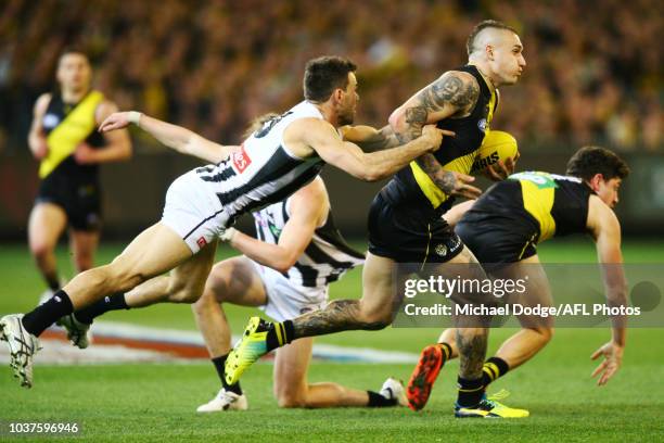 Levi Greenwood of the Magpies tackles Dustin Martin of the Tigers during the AFL Preliminary Final match between the Richmond Tigers and the...