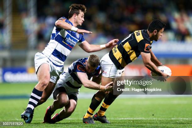 Stephen Perofeta of Taranaki is tackled by Harry Plummer and Jordan Trainor of Auckland during the round six Mitre 10 Cup match between Taranaki and...