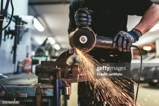 schwerindustrie arbeitnehmer schneiden von stahl mit einem winkelschleifer. - technology strength stock-fotos und bilder