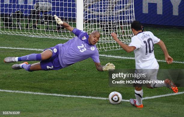 Striker Landon Donovan tries for a chance on goal as Algeria's goalkeeper M'bolhi Rais Ouheb defends the goal during their Group C first round 2010...