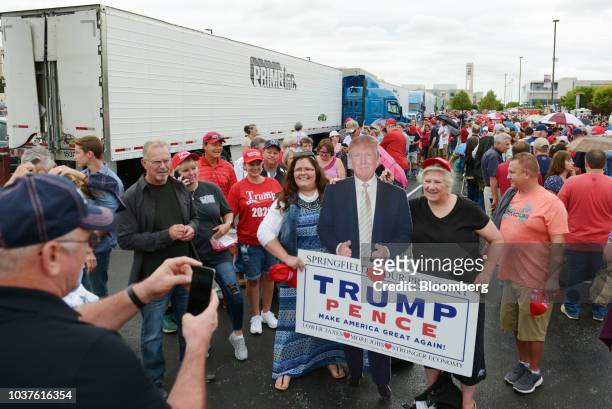 Supporters pose for photographs with a cardboard cutout of U.S. President Donald Trump ahead of a rally in Springfield, Missouri, U.S., on Friday,...