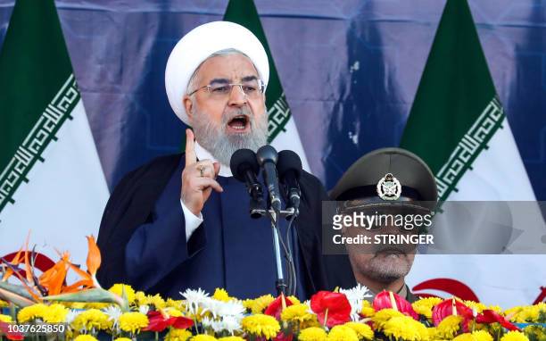 Iranian President Hassan Rouhani delivers a speech during the annual military parade marking the anniversary of the outbreak of the devastating...