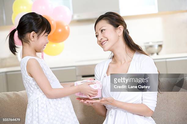 daughter gives mother a present - mamma bambina palloncino bianco foto e immagini stock