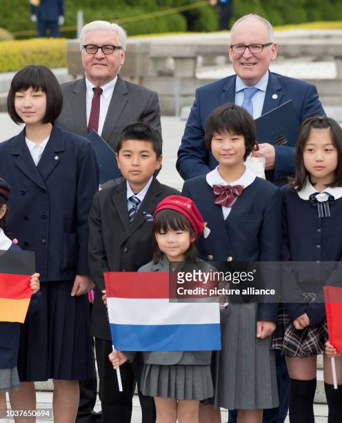 German Foreign Minister Frank-Walter Steinmeier and the Dutch Foreign Minister Frans Timmermans stand behind Japanese children next to the cenotaph...