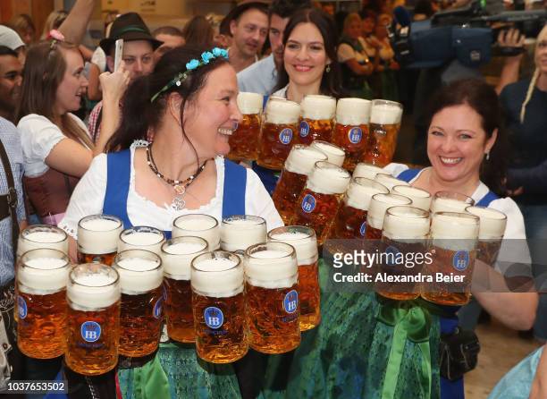 Waitresses carry beer steins in a beer tent on the opening day of the 2018 Oktoberfest beer festival on September 22, 2018 in Munich, Germany. The...