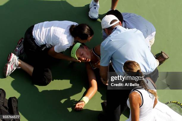 Victoria Azarenka of Belarus is tended to by medical personnel on the court after she collapsed during her second round women's singles match against...