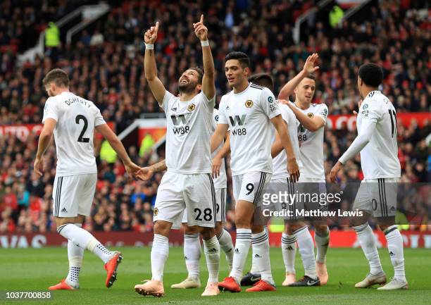 Joao Moutinho of Wolverhampton Wanderers celebrates after scoring his team's first goal with his team mates during the Premier League match between...