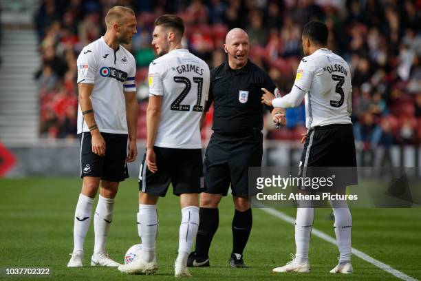 Mike van der Hoorn , Matt Grimes and Martin Olsson of Swansea City protest to referee Simon Hooper during the Sky Bet Championship match between...