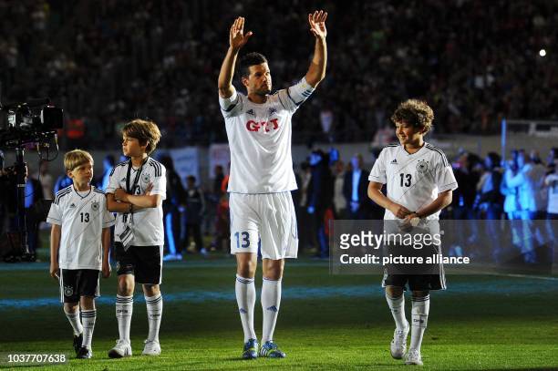 German soccer player Michael Ballack bids farewell to his fans with his three sons during his final soccer match at the Red Bull Arena in Leipzig,...