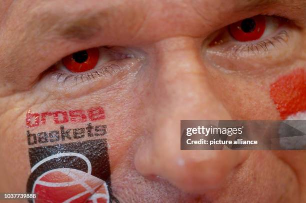 Fan of Bamberg wears red contact lenses and a Brose Baskets sticker on his cheek during the Basketball Bundesliga Playoffs final match between Brose...