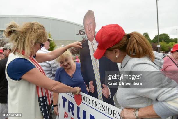 Attendees stand for photographs with a cardboard cutout of U.S. President Donald Trump ahead of a rally in Springfield, Missouri, U.S., on Friday,...