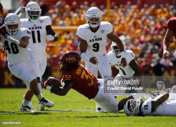 Running back David Montgomery of the Iowa State Cyclones is tackled by linebacker Brian Bell of the Akron Zips as his teammates linebacker John Lako,...