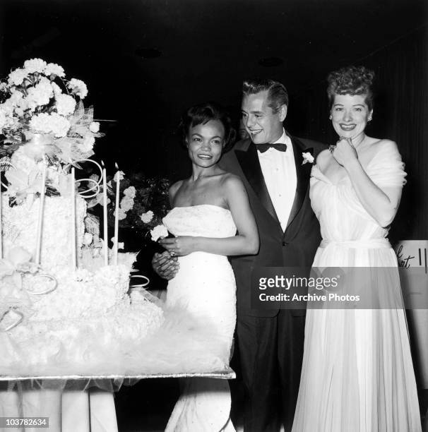 From right to left, American actress Lucille Ball with her husband Desi Arnaz and singer Eartha Kitt at a surprise party for Arnaz and Ball's 13th...
