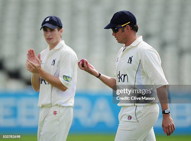 Neil Carter and Chris Woakes of Warwickshire walk off the pitch after winning the match during day three of the LV County Championship match between...