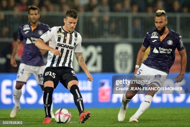 Angers' French midfielder Pierrick Capelle vies with Toulouse's Trinidadian midfielder John Bostock during the French L1 football match between...