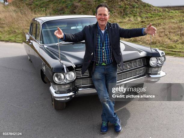 Der Oldtimer-Händler Michael Frölich posiert am mit ausgebreiteten Armen in seiner Firma in Mettmann vor der ehemalige Staats-Limousine des Schahs...