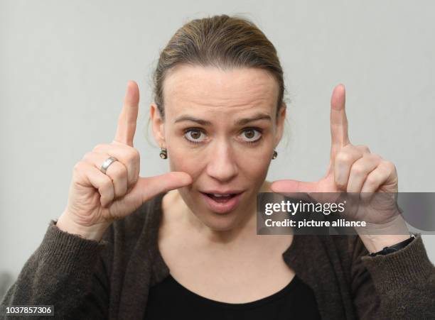 Die Gebärdendolmetscherin Kathrin-Maren Enders zeigt am in Frankfurt am Main mit ihren Fingern das Wort "wach" in Gebärdensprache. Die Einführung der...