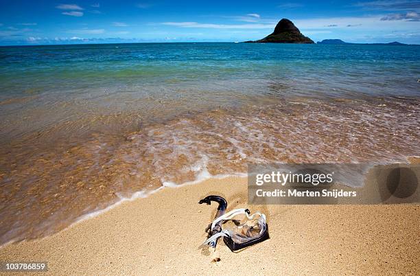 snorkel gear on beach of kualoa regional park with mokolii mokoli’i island in background. - クアロア公園 ストックフォトと画像