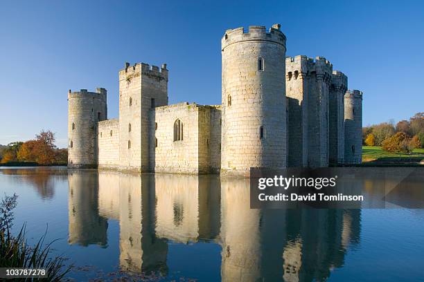 bodiam castle with surrounding moat, in autumn. - moat stock pictures, royalty-free photos & images