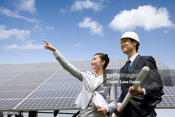 two engineers in front of solar panels - 電源供應器 個照片及圖片檔