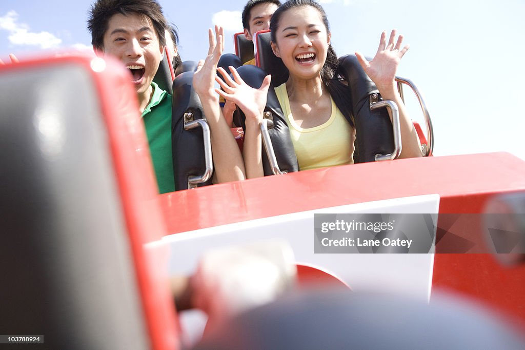 Young people riding a rollercoaster