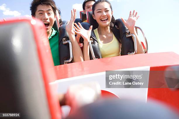 young people riding a rollercoaster - young woman screaming on a rollercoaster stock pictures, royalty-free photos & images