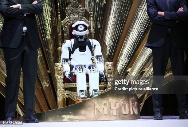 Robot named 'Myon' sits between two bodyguards during a rehearsal of the opera 'My Square Lady' in Berlin, Germany, 18 June 2015. The opera featuring...