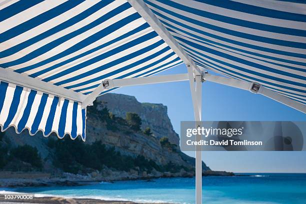 striped canvas awning beside beach at cap canaille. - awning stock pictures, royalty-free photos & images