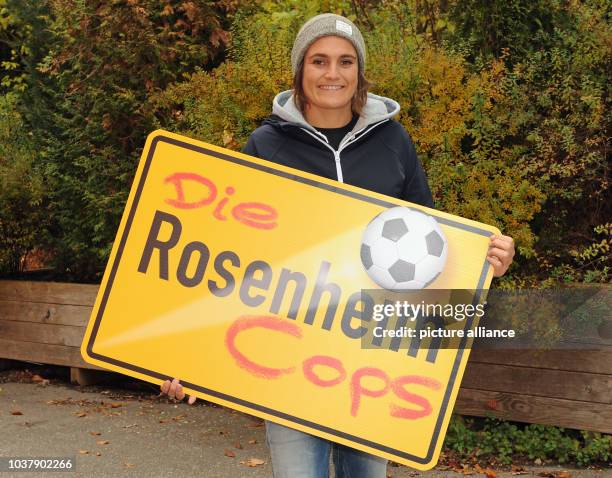 Dpa-exclusive - Former German soccer player Nadine Angerer poses with a 'Rosenheim' traffic sign during filming for the ZDF crime show 'Die...