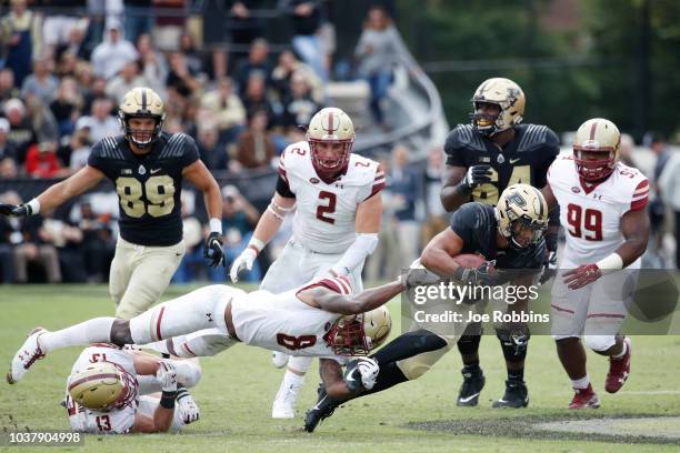 Markell Jones of the Purdue Boilermakers tries to slip out of the grasp of Will Harris of the Boston College Eagles in the third quarter of the game...
