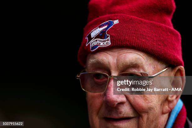 An elderly fan of Scunthorpe United wearing a branded wolly hat during the Sky Bet League One match between Scunthorpe United and Shrewsbury Town at...