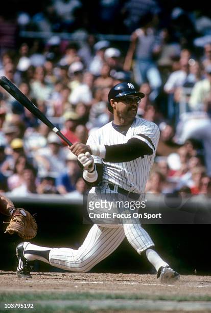 Outfielder Reggie Jackson of the New York Yankees swings and watches the flight of his ball during a Major League Baseball game circa 1981 at Yankee...