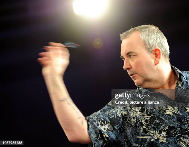 English dart player Phil Taylor throws a dart during a show tournament with HSV players against the Professional Darts Corporation in Hamburg,...