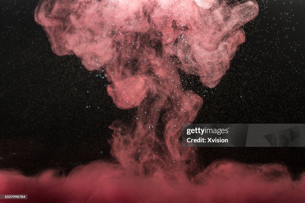 Red color drop into water with bubbles