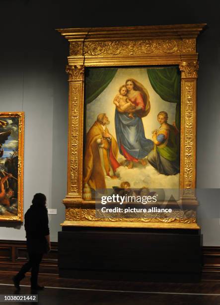 Woman observes Raffael's 'Sistine Madonna' from 1513 at the Gobelin hall of the Gemaeldegalerie Alte Meister in Dresden, Germany, 27 March 2013. The...