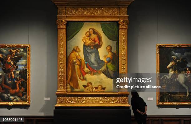 Woman observes Raffael's 'Sistine Madonna' from 1513 at the Gobelin hall of the Gemaeldegalerie Alte Meister in Dresden, Germany, 27 March 2013. The...