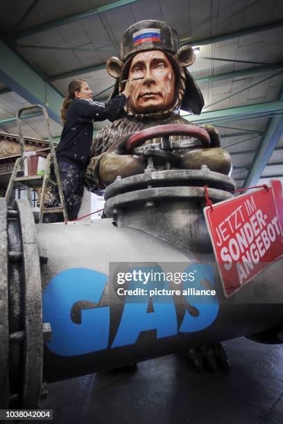 Worker puts the finishing touches on float 106 , which depicts Vladimir Putin as a bear at a fuel valve in the float hall at the Mainz Carnival Union...
