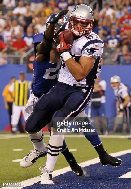 Rob Gronkowski of the New England Patriots carries a reception into the endzone past Antrel Rolle of the New York Giants for a first quarter...